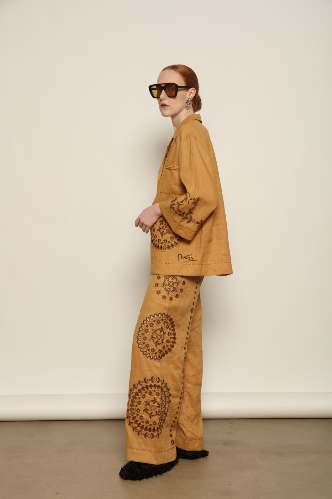 Model is wearing the My Sleeping Gypsy Sarah Jacket, an ivory linen jacket with hand-cut lace, intricate embroidery, and 24-carat bead accents, from the House of Nomad Stories selection.