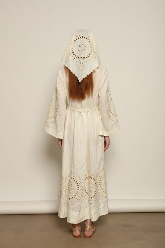 Model is wearing the My Sleeping Gypsy Sarah Long Dress in Ivory, handcrafted from linen with delicate lace, embroidery, and 24-carat bead accents, from the House of Nomad Stories selection.