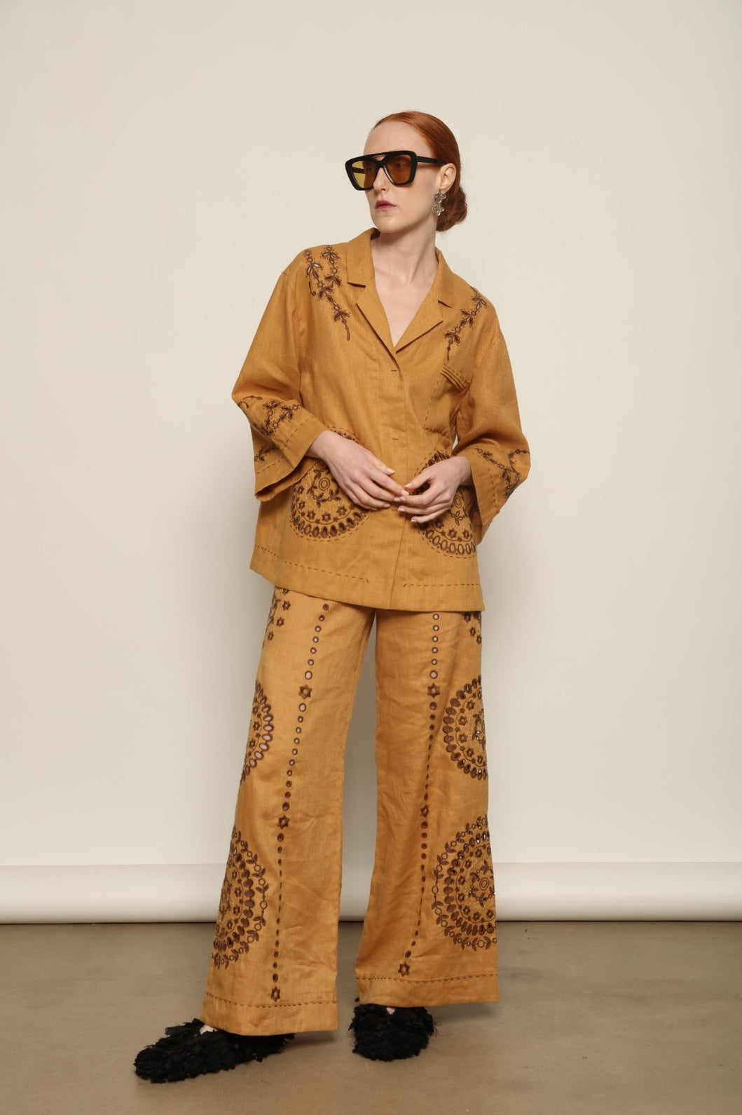 Model is wearing the My Sleeping Gypsy Sarah Pants, high-waisted 100% linen trousers with handmade lace, tonal embroidery, and 24-carat bead accents, from the House of Nomad Stories selection.