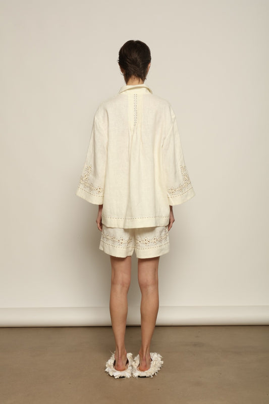 Model is wearing the My Sleeping Gypsy Sarah Suit, a handcrafted ivory linen set with high-waisted shorts, relaxed jacket, intricate embroidery, and 24-carat bead accents, from the House of Nomad Stories selection.