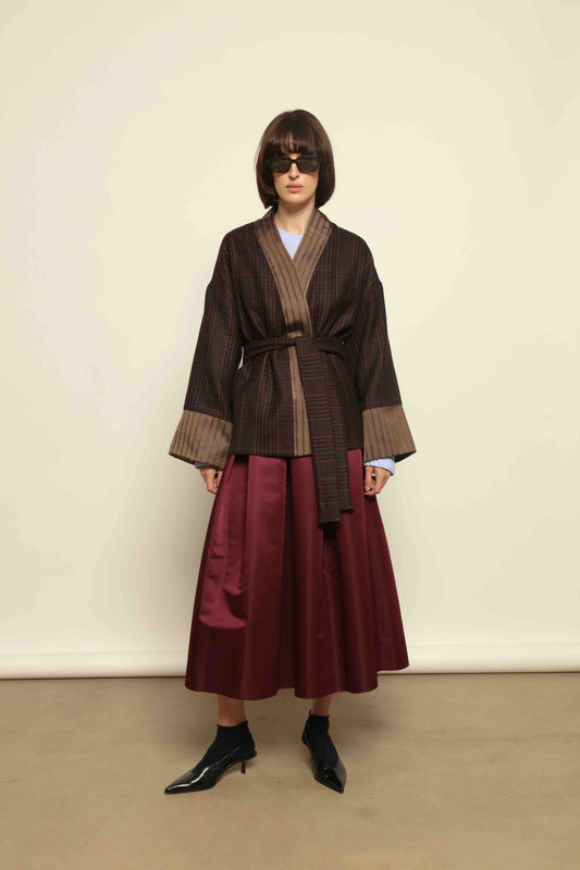 Model is wearing the Obidi Checked Kantha Jacket in wool and silk with a refined silk collar and unique printed silk lining, crafted with artisanal Kantha technique. Part of House of Woven Stories selection.