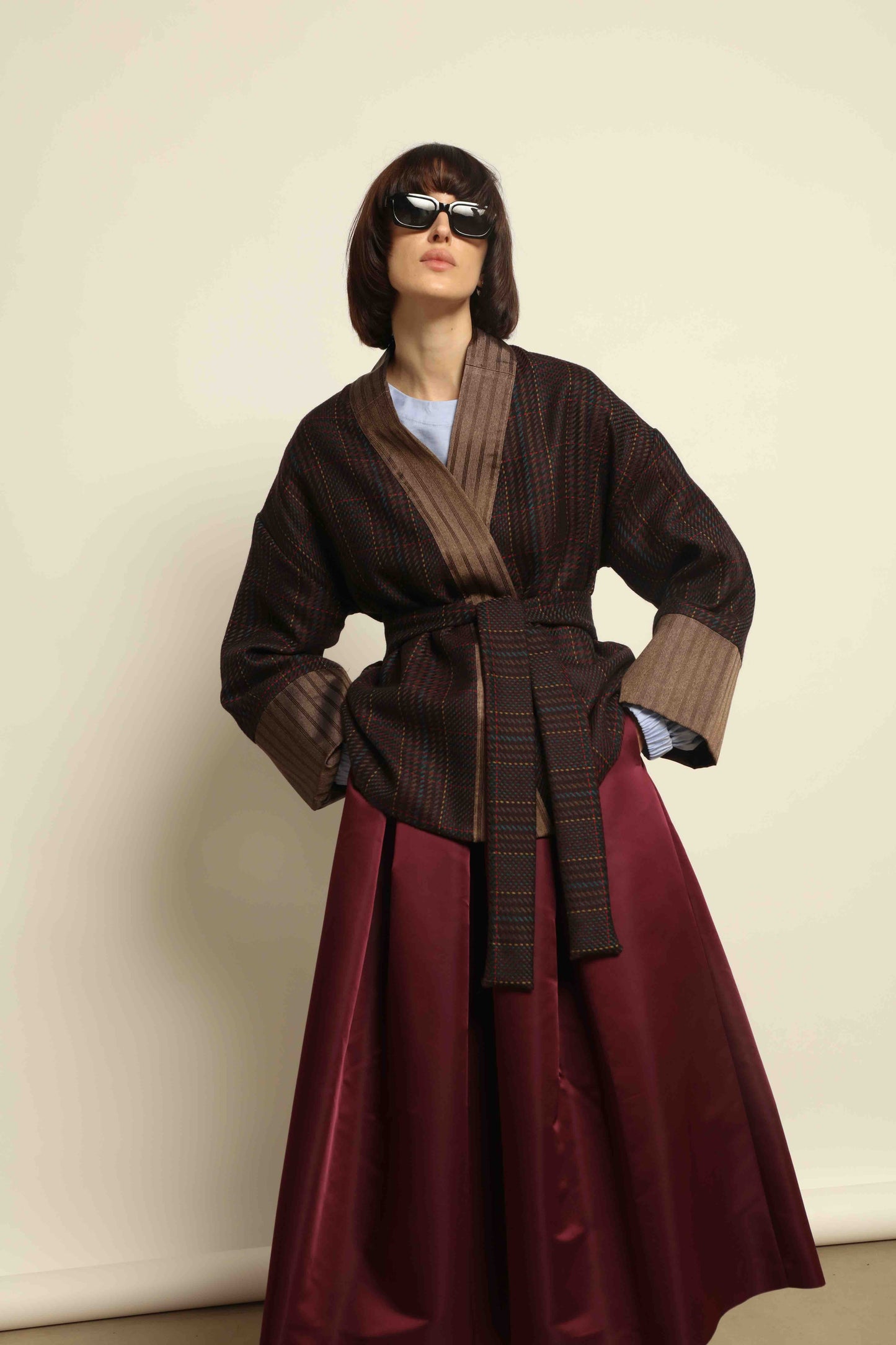 Model is wearing the Obidi Checked Kantha Jacket in wool and silk with a refined silk collar and unique printed silk lining, crafted with artisanal Kantha technique. Part of House of Woven Stories selection.