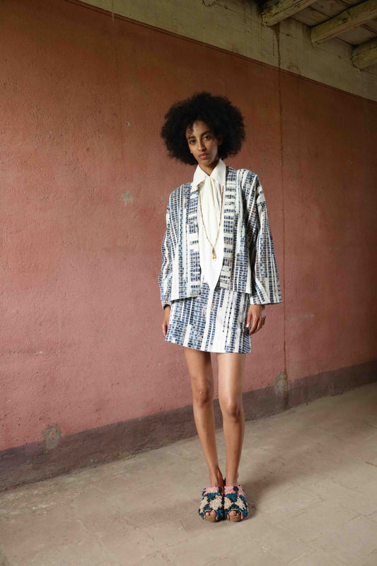 Handwoven mini skirt in upcycled blue and white cotton fabric with voile lining. Sustainable, eco-friendly fashion by Paiwand. Artisan-crafted, ethical clothing with unique texture. Matching kimono available. Part of House of Woven Stories curated collection.