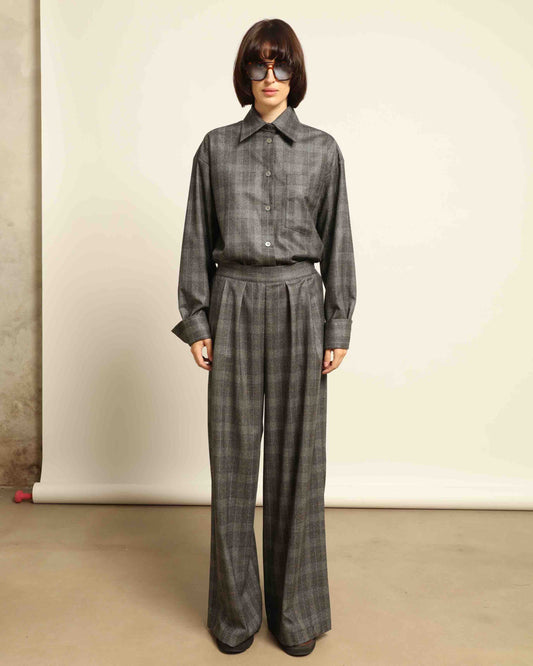 Model is wearing the Parigi Grey Check Trousers by House of Woven Stories, featuring a refined grey check pattern and a tailored silhouette, handcrafted in Piedmont, Italy.