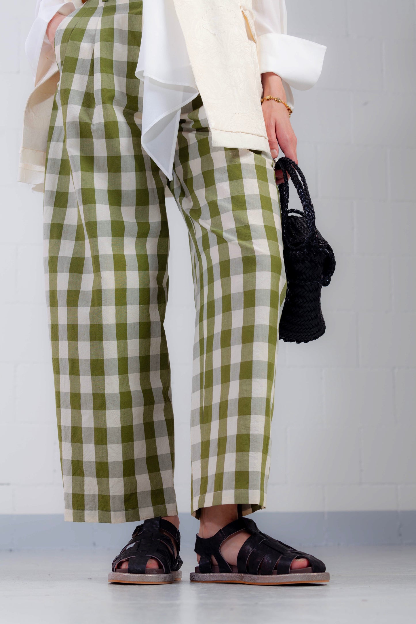 Model is wearing the Pine Checked Trousers by Balia 8.22, handcrafted in Italy from cotton and linen, featuring a relaxed straight-leg fit with pine green and white check pattern.