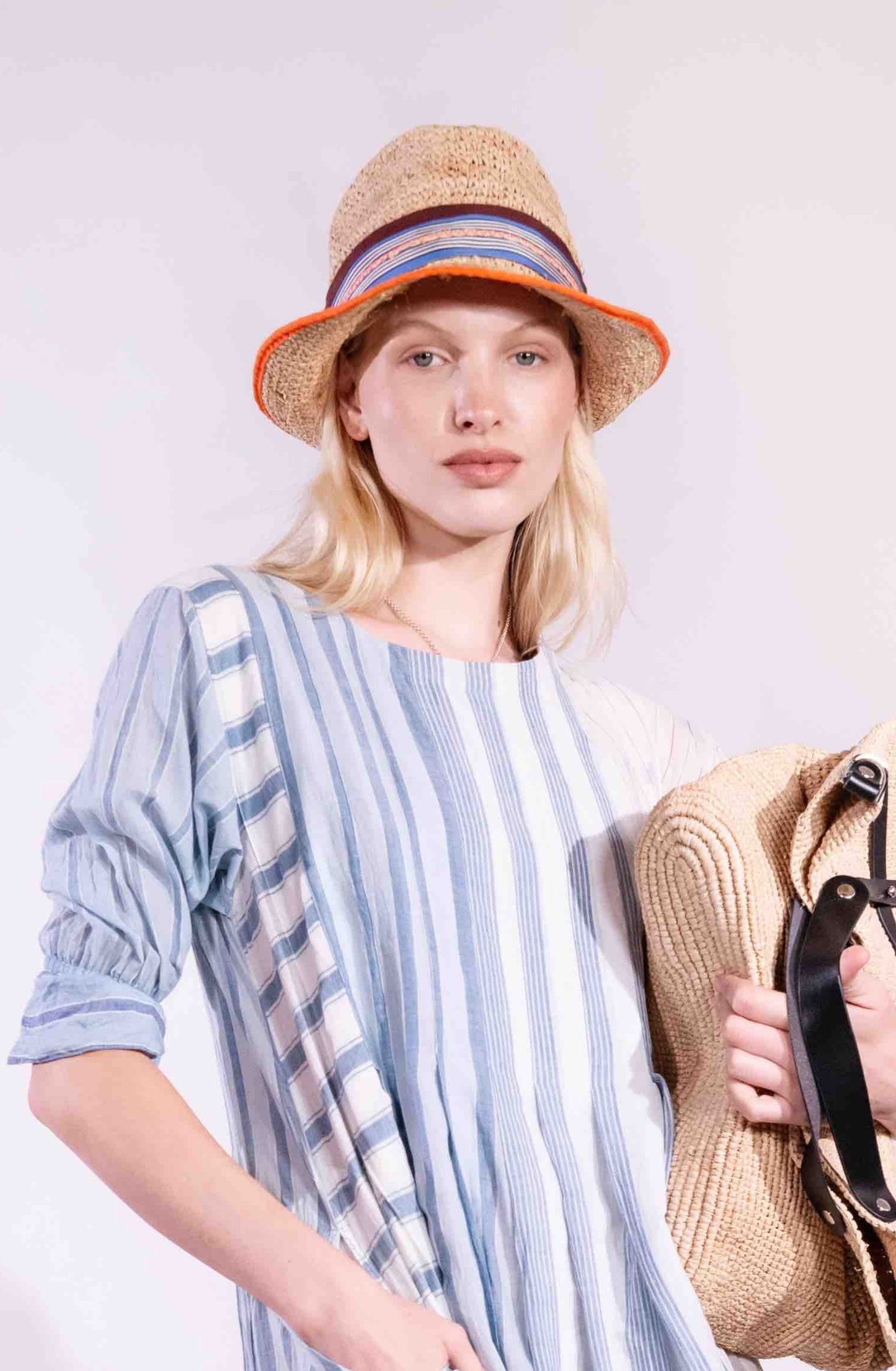 The Pool Boy Raffia Hat by Lola Hats is a handmade, durable summer accessory crafted from sturdy straw-like paper with colorful grosgrain trim. Perfect for town or beach, made in Brooklyn. Available at House of Woven Stories.