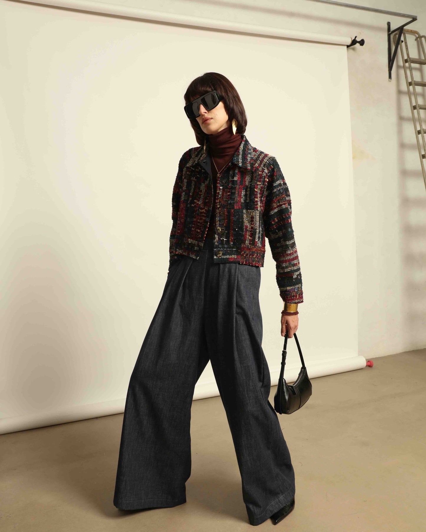 Model is wearing the Rewoven Hand-loomed Bomber by Paiwand, an upcycled unisex jacket crafted from handwoven organic cotton off-cuts with unique color and design variations.