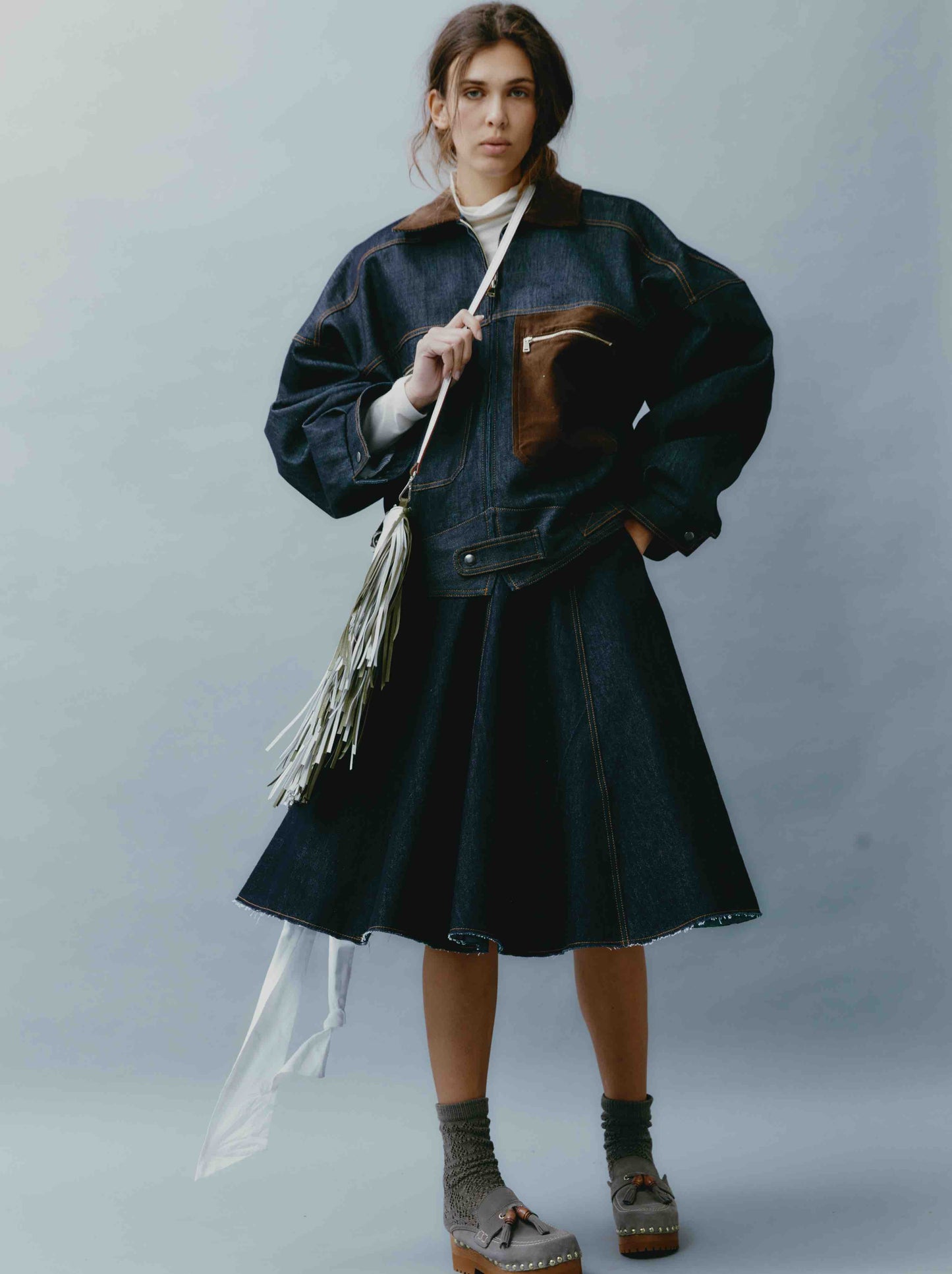 Model is wearing the Sissi Short Blue Jeans Skirt by Maison Jejia, part of the House of Woven Stories selection, featuring dark blue denim, a structured fit, subtle edgy details, and a polished silhouette.