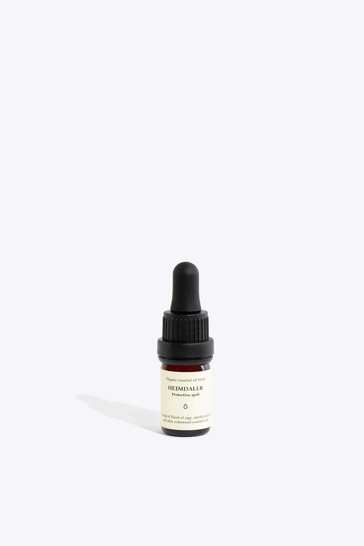 Organic essential oil blend Heimdallr by Smells Like Spells in a glass bottle with dropper, designed for protection and home energy cleansing, offered by House of Woven Stories.