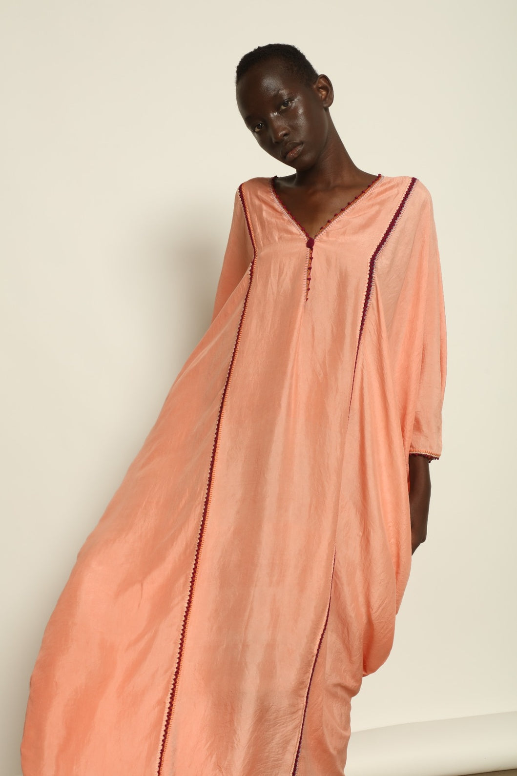 Model is wearing the Thea Rose Silk Dress by Supernaturae x HONS, crafted in handwoven silk from Murshidabad with a soft botanical rose dye finish, featuring a relaxed flowing silhouette and deep open back design. Part of the House of Woven Stories selection, this sustainable slow luxury piece reflects ethical artisan craftsmanship and natural dye variations.