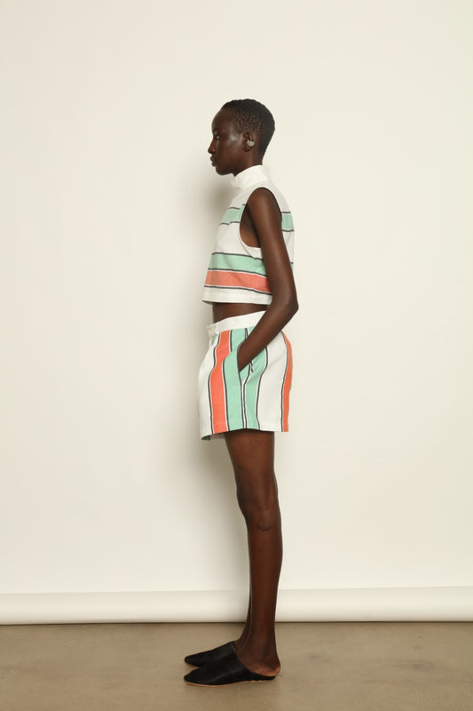 Model is wearing The Pleated Short by Marrakshi Life, part of House of Nomad Stories collection, handwoven artisanal cotton shorts with deep front pleats, high waist, and relaxed sculptural silhouette