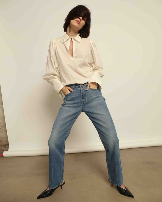 Model is wearing the Tilda Mid-Rise Draped Straight Jean by B Sides in classic indigo denim, mid-rise fit with straight tapered leg and curved inseam for a leg-lengthening silhouette.