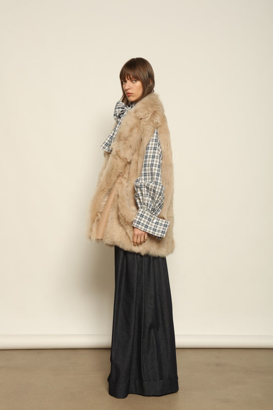 Model is wearing the Toscana Sabbia Shearling Vest by Blancha – a 100% Toscana sheepskin vest made in Italy, featuring a soft natural texture, warm drape, and refined Sabbia tone, styled for effortless layering and timeless elegance.