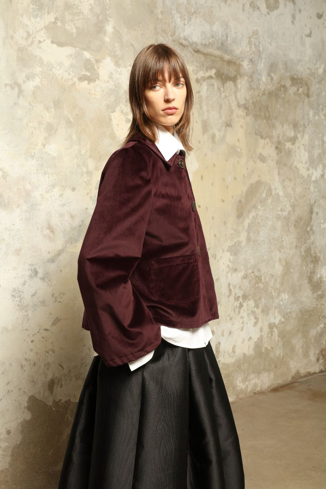 Model is wearing the Katharina Velvet Burgundy Cotton Jacket by House of Woven Stories, crafted from cotton velvet with an A-shape silhouette and hand-printed silk lining.