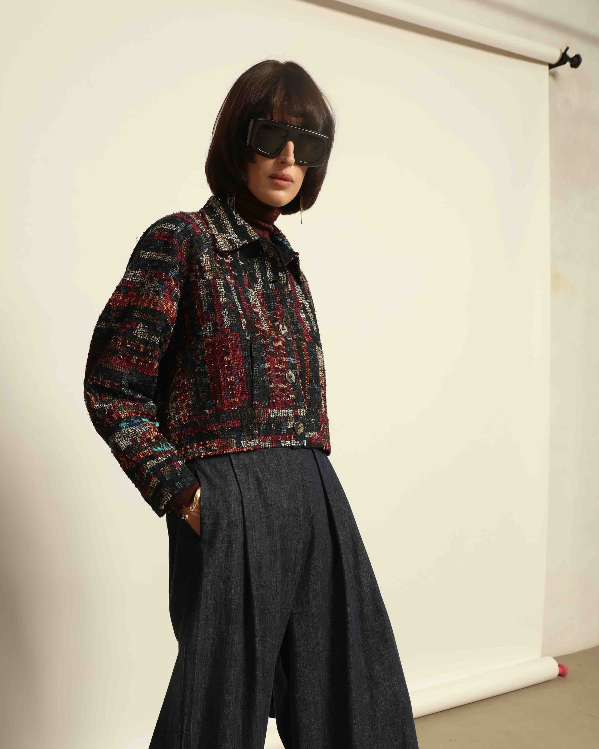 Model is wearing the Rewoven Hand-loomed Bomber by Paiwand, an upcycled unisex jacket crafted from handwoven organic cotton off-cuts with unique color and design variations.