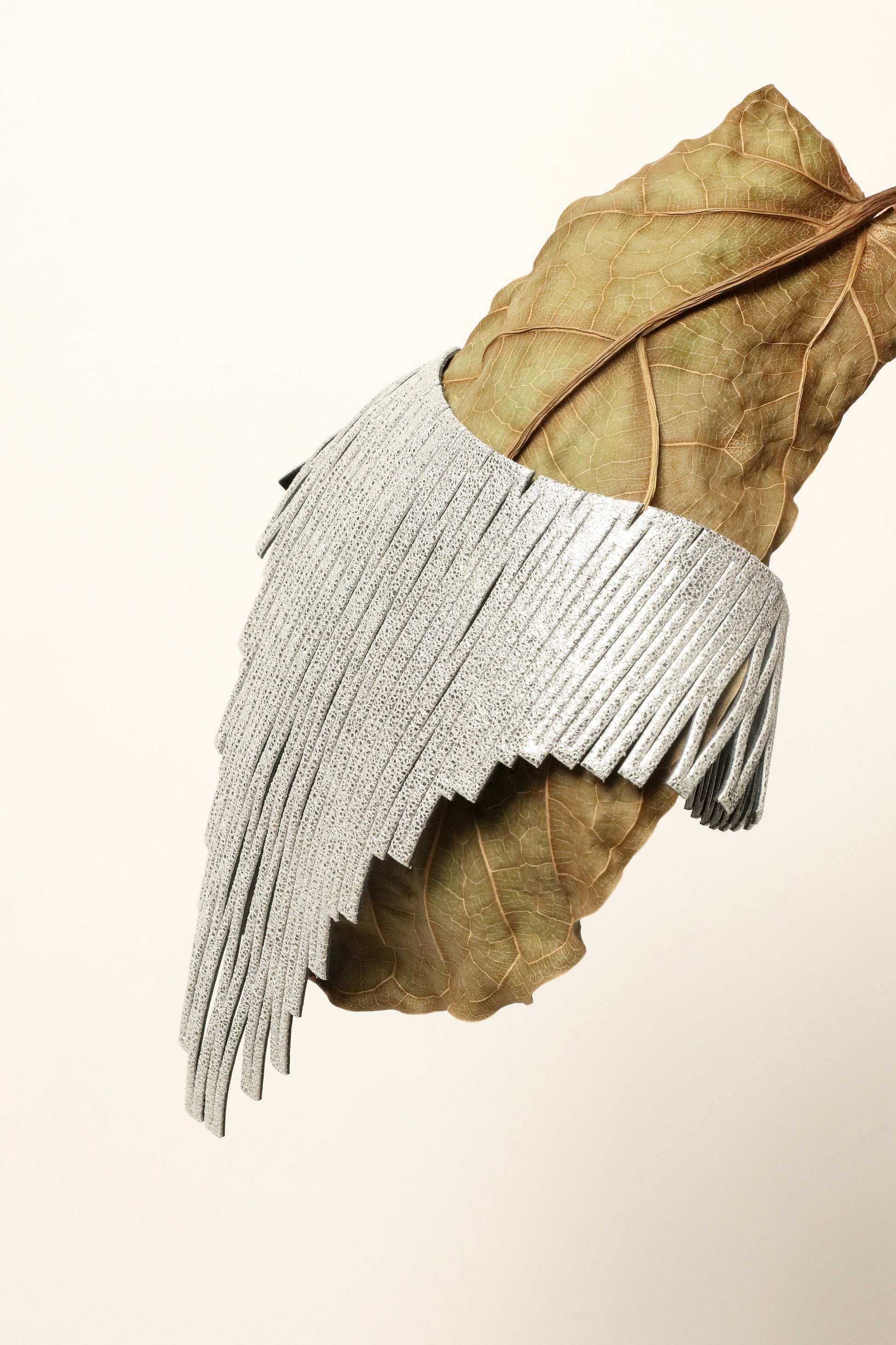 Luminous Silver leather necklace by SO-LE STUDIO, handcrafted in Tuscany, silver-toned diamond-shaped elements in a cascading sculptural design, lightweight and fluid on the neckline