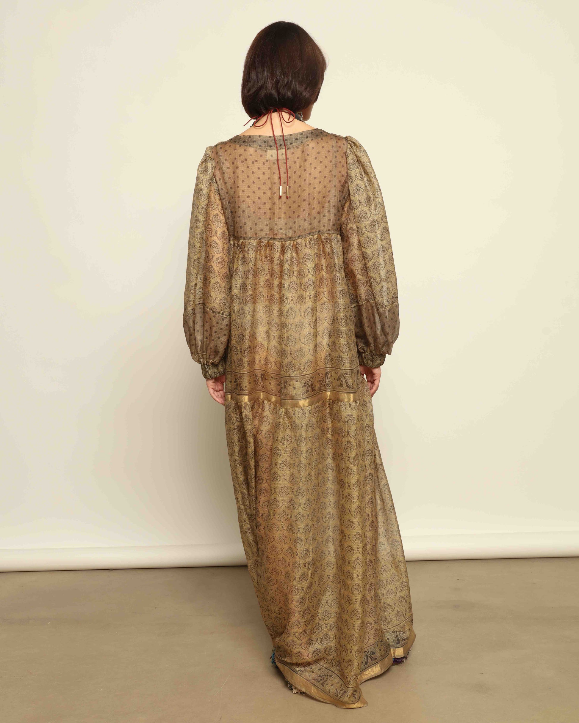 Model is wearing vintage-inspired maxi dress in lightweight 100% silk chiffon with square neckline, voluminous sleeves, and delicate all-over print. Part of House of Woven Stories selection.