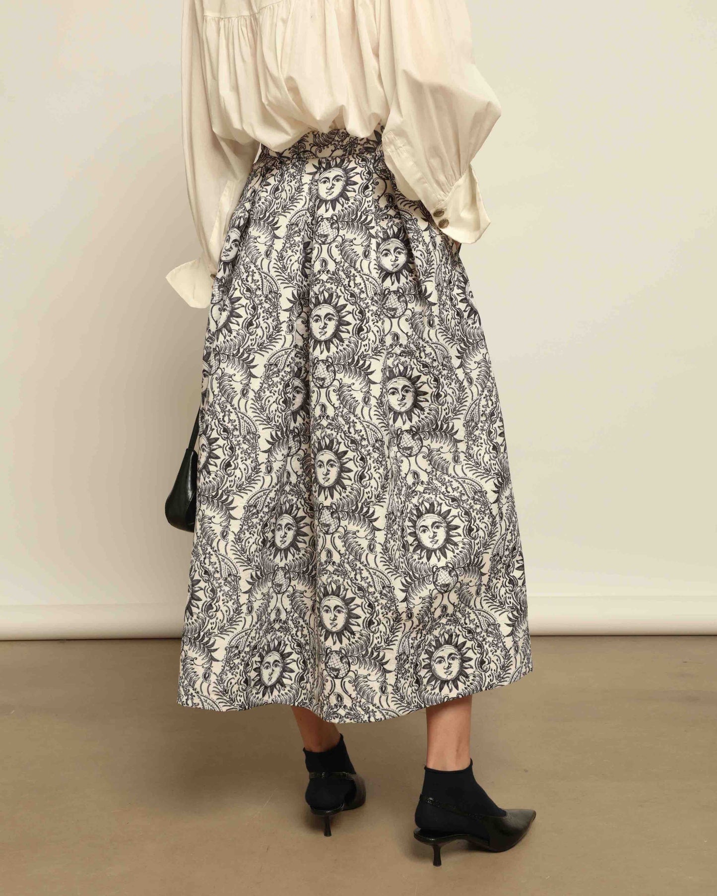 Model is wearing Sun Black and White Skirt by Lunatica Milano. Romantic floral skirt in classic black and white. Elegant, feminine, and handcrafted in Italy. Part of House of Woven Stories selection.