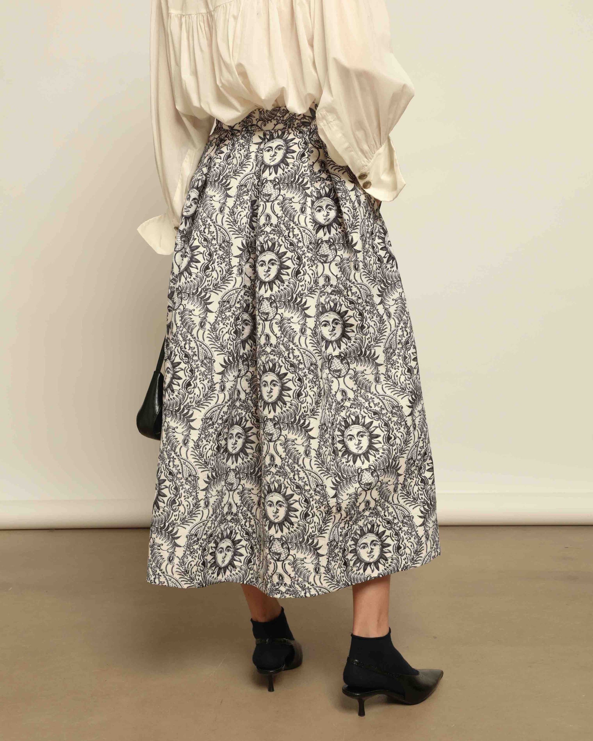 Model is wearing Sun Black and White Skirt by Lunatica Milano. Romantic floral skirt in classic black and white. Elegant, feminine, and handcrafted in Italy. Part of House of Woven Stories selection.