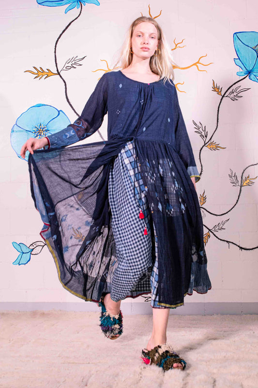 Model wearing pure cotton dress by Injiri – navy blue handloomed summer dress with jamdani weaving, contrast trim, long sleeves, and adjustable drawstring waist. Made from 100% organic cotton and handcrafted in India.