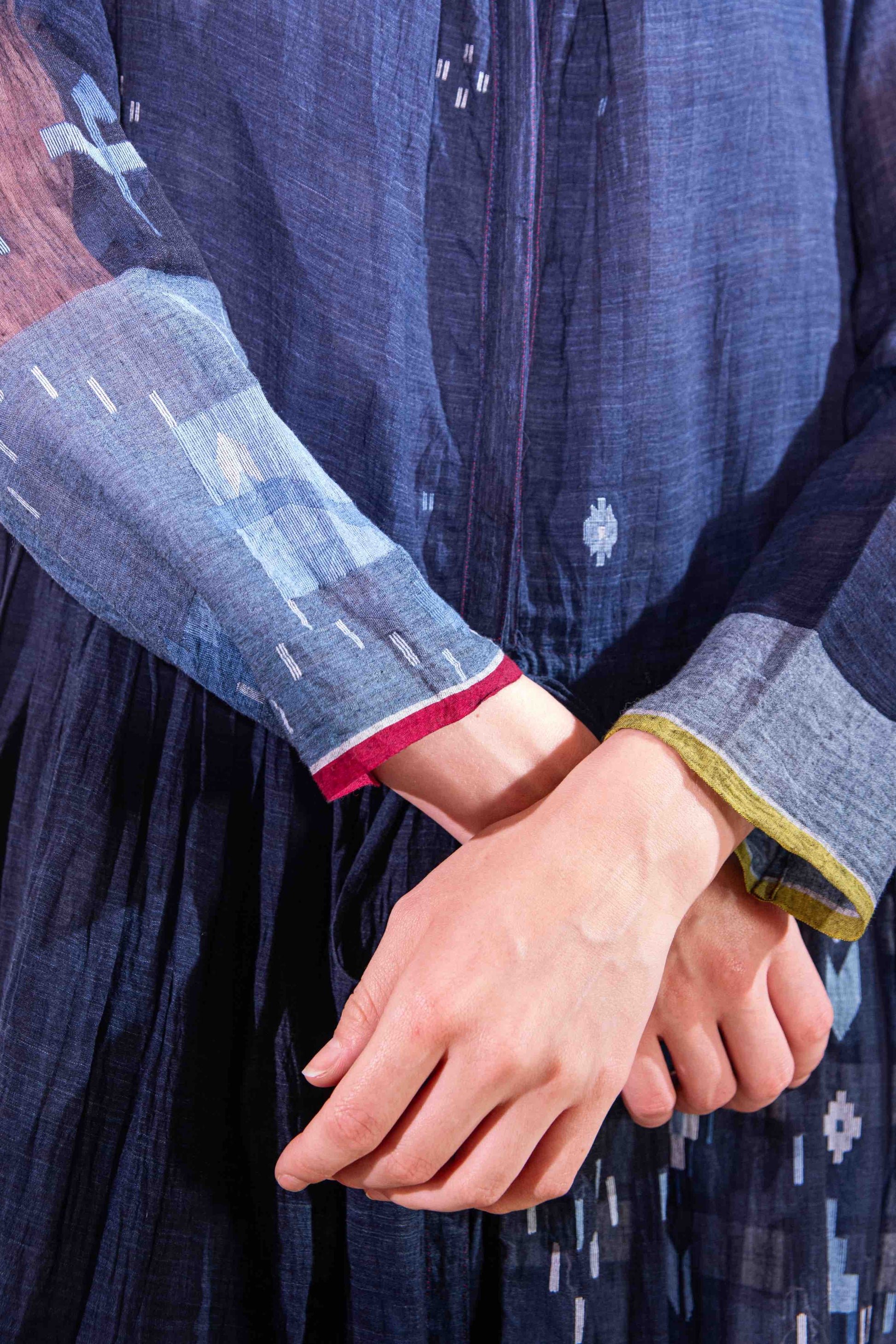 Model wearing pure cotton dress by Injiri – navy blue handloomed summer dress with jamdani weaving, contrast trim, long sleeves, and adjustable drawstring waist. Made from 100% organic cotton and handcrafted in India.