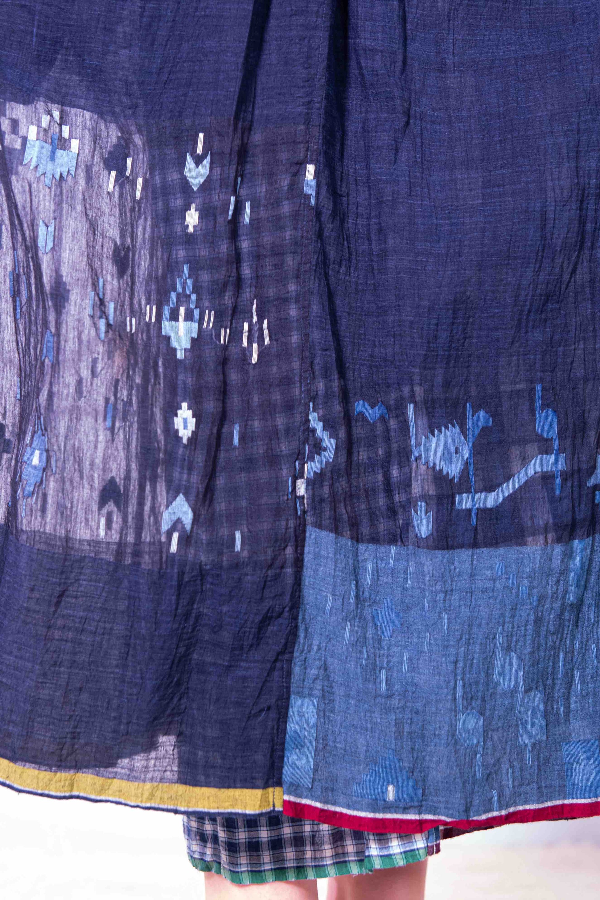 Model wearing pure cotton dress by Injiri – navy blue handloomed summer dress with jamdani weaving, contrast trim, long sleeves, and adjustable drawstring waist. Made from 100% organic cotton and handcrafted in India.