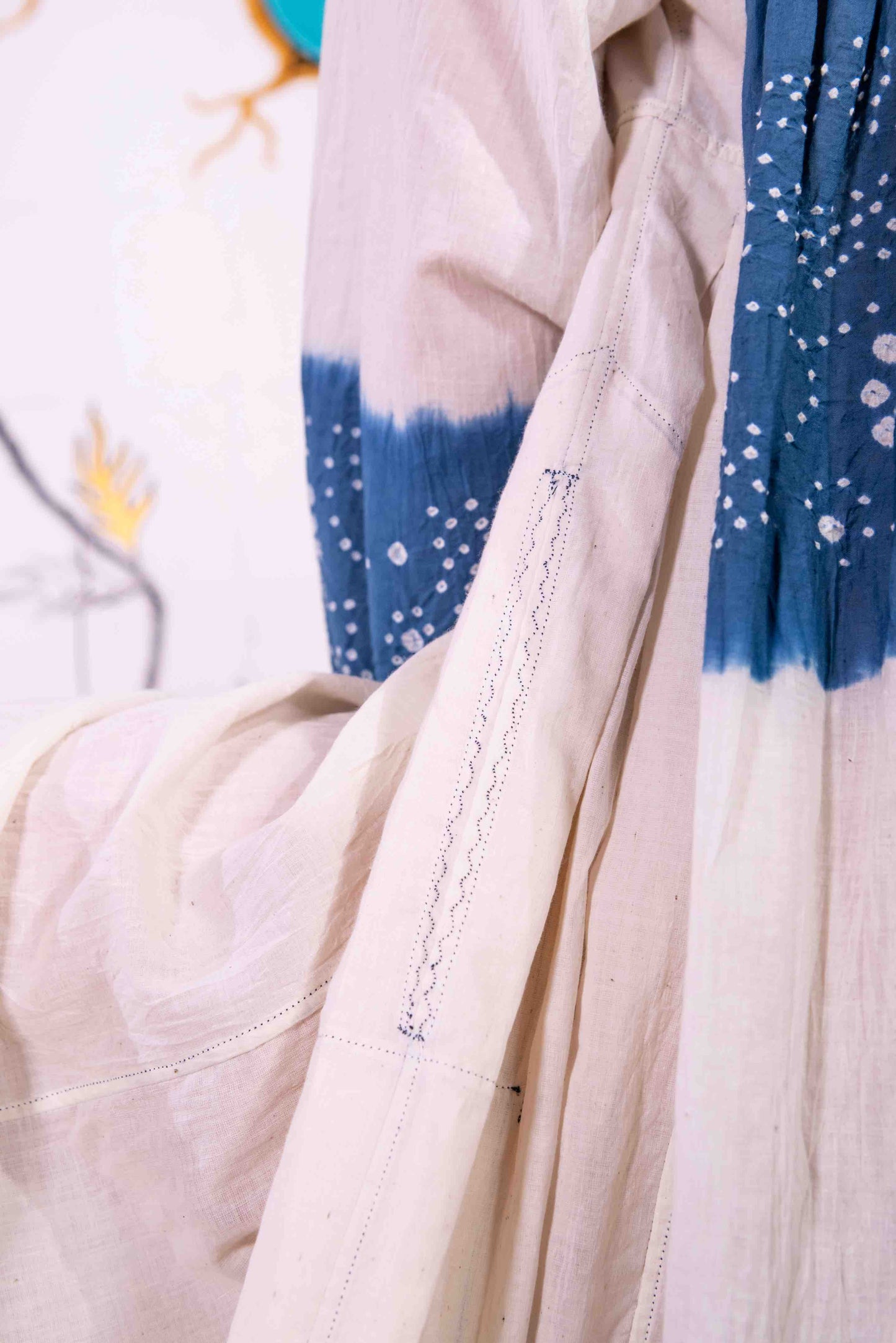 Model wearing pure cotton maxi dress by Injiri – long-sleeve off-white handloomed dress with indigo tie-dye and shibori print, side pockets, and fluid silhouette. Handcrafted in India using organic cotton.