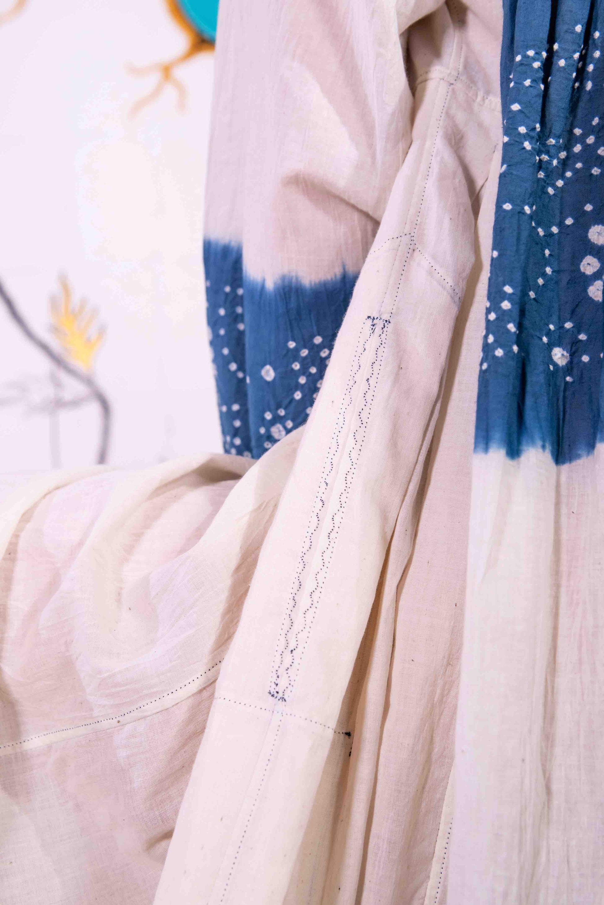 Model wearing pure cotton maxi dress by Injiri – long-sleeve off-white handloomed dress with indigo tie-dye and shibori print, side pockets, and fluid silhouette. Handcrafted in India using organic cotton.