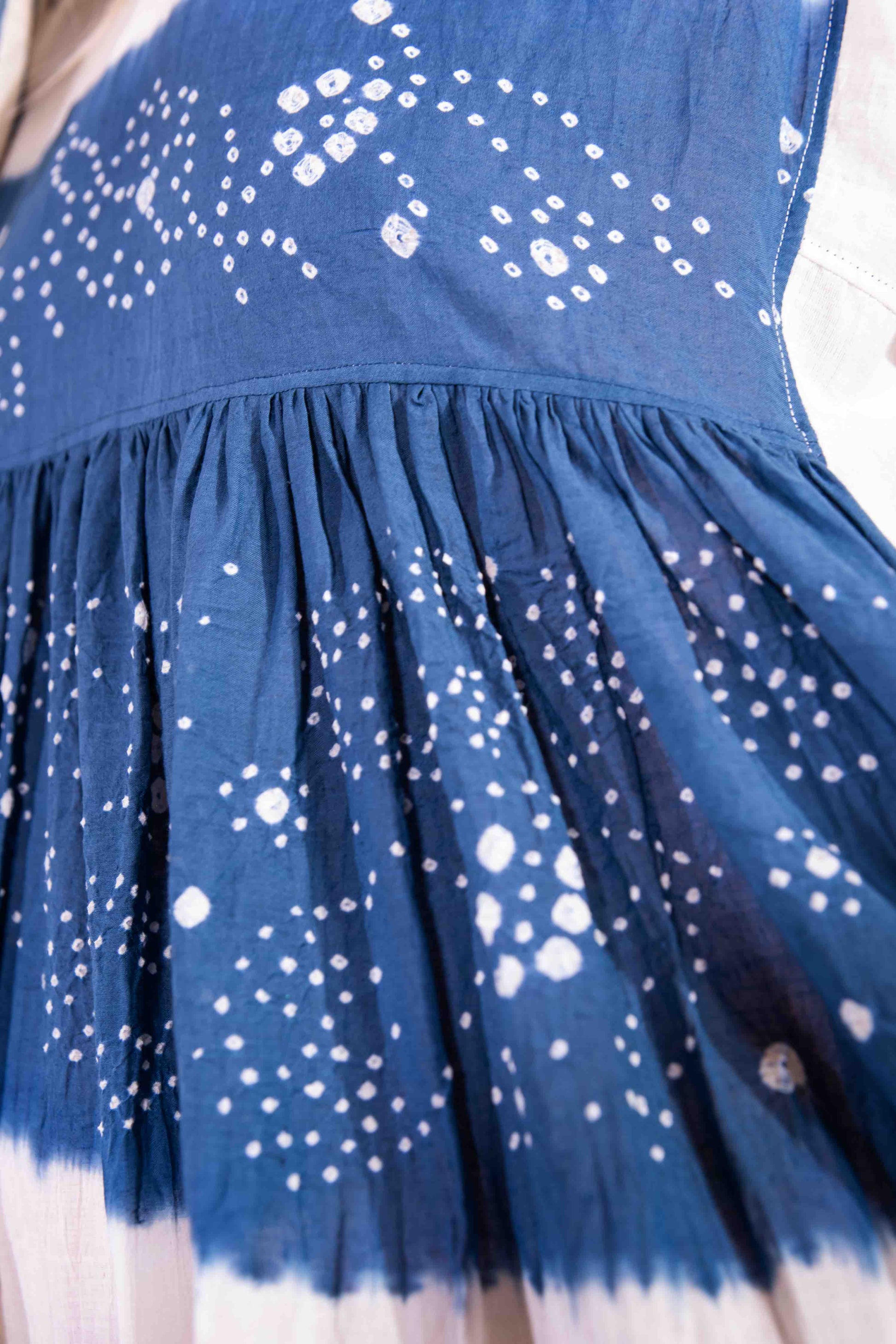 Model wearing pure cotton maxi dress by Injiri – long-sleeve off-white handloomed dress with indigo tie-dye and shibori print, side pockets, and fluid silhouette. Handcrafted in India using organic cotton.