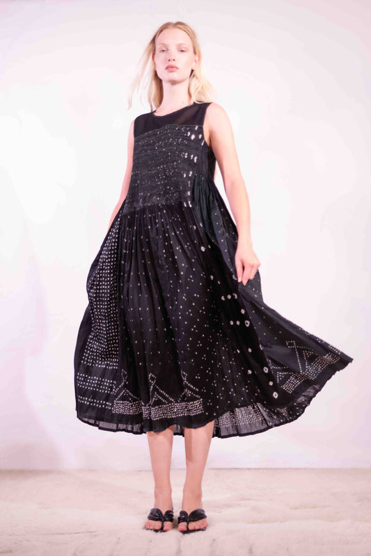 Model is wearing a long, flowing silk-cotton blend dress in black with navy and white accents. Features a softly flared skirt. Handmade in India with traditional techniques by Injiri.