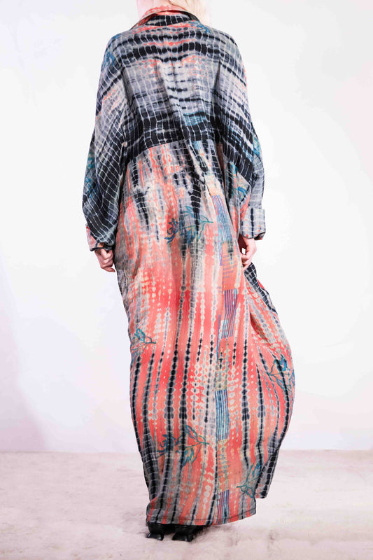 Model wearing the Barcelona Breeze Dress - a handcrafted silk dress with batwing sleeves, V-neck, and Shibori-dyed pattern, made in Italy by House of Woven Stories.