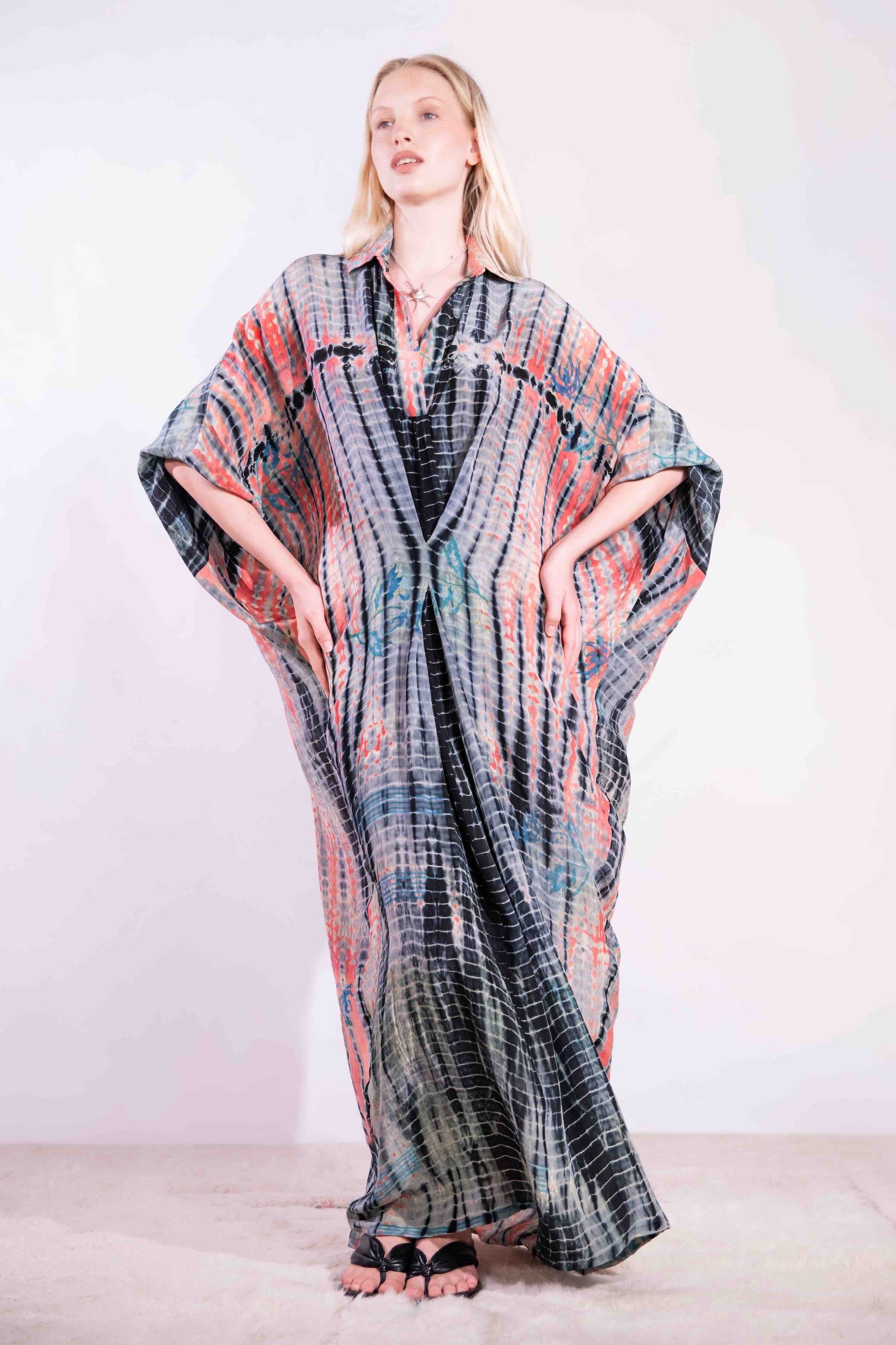 Model wearing the Barcelona Breeze Dress - a handcrafted silk dress with batwing sleeves, V-neck, and Shibori-dyed pattern, made in Italy by House of Woven Stories.