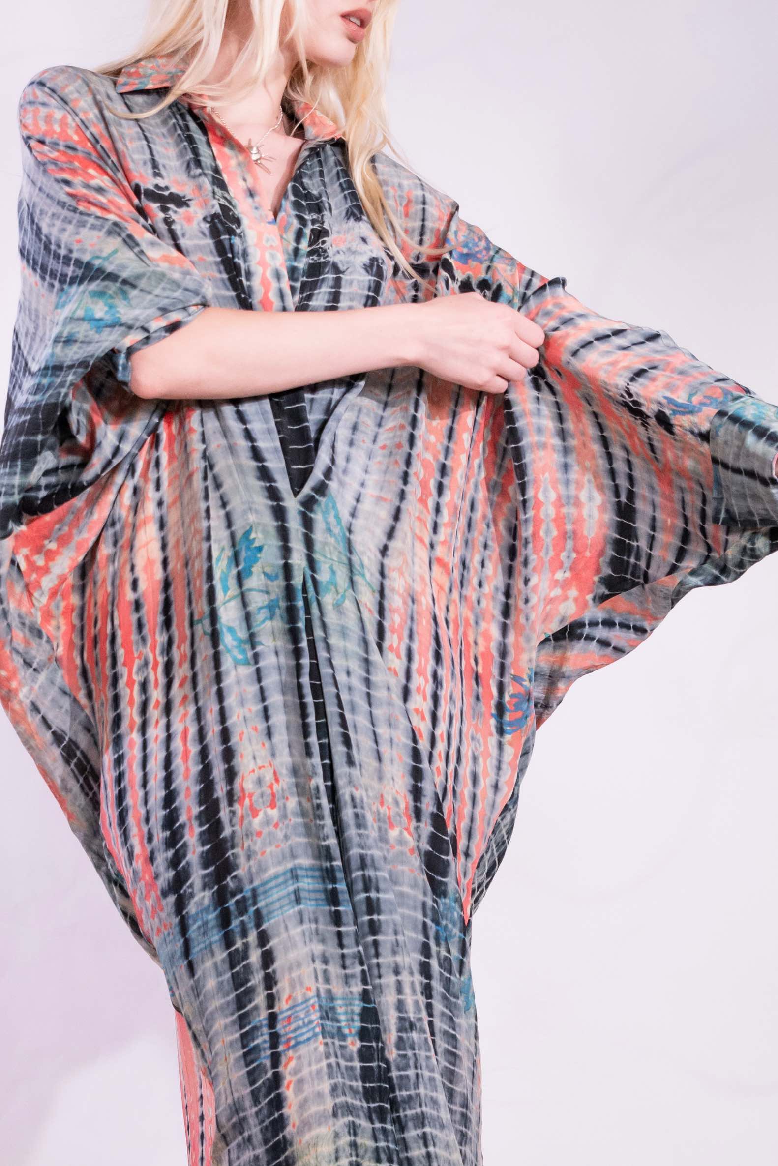 Model wearing the Barcelona Breeze Dress - a handcrafted silk dress with batwing sleeves, V-neck, and Shibori-dyed pattern, made in Italy by House of Woven Stories.