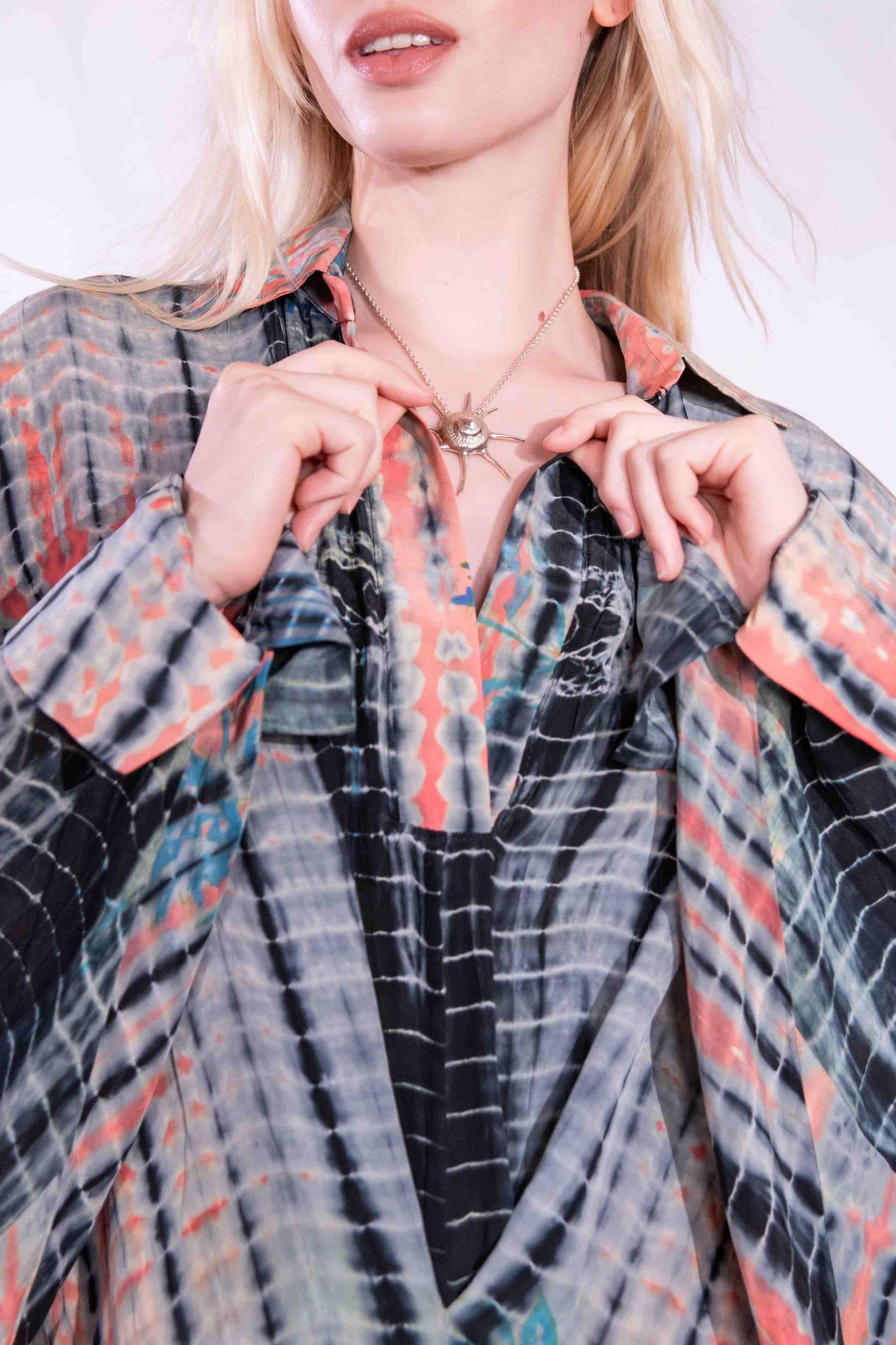 Model wearing the Barcelona Breeze Dress - a handcrafted silk dress with batwing sleeves, V-neck, and Shibori-dyed pattern, made in Italy by House of Woven Stories.
