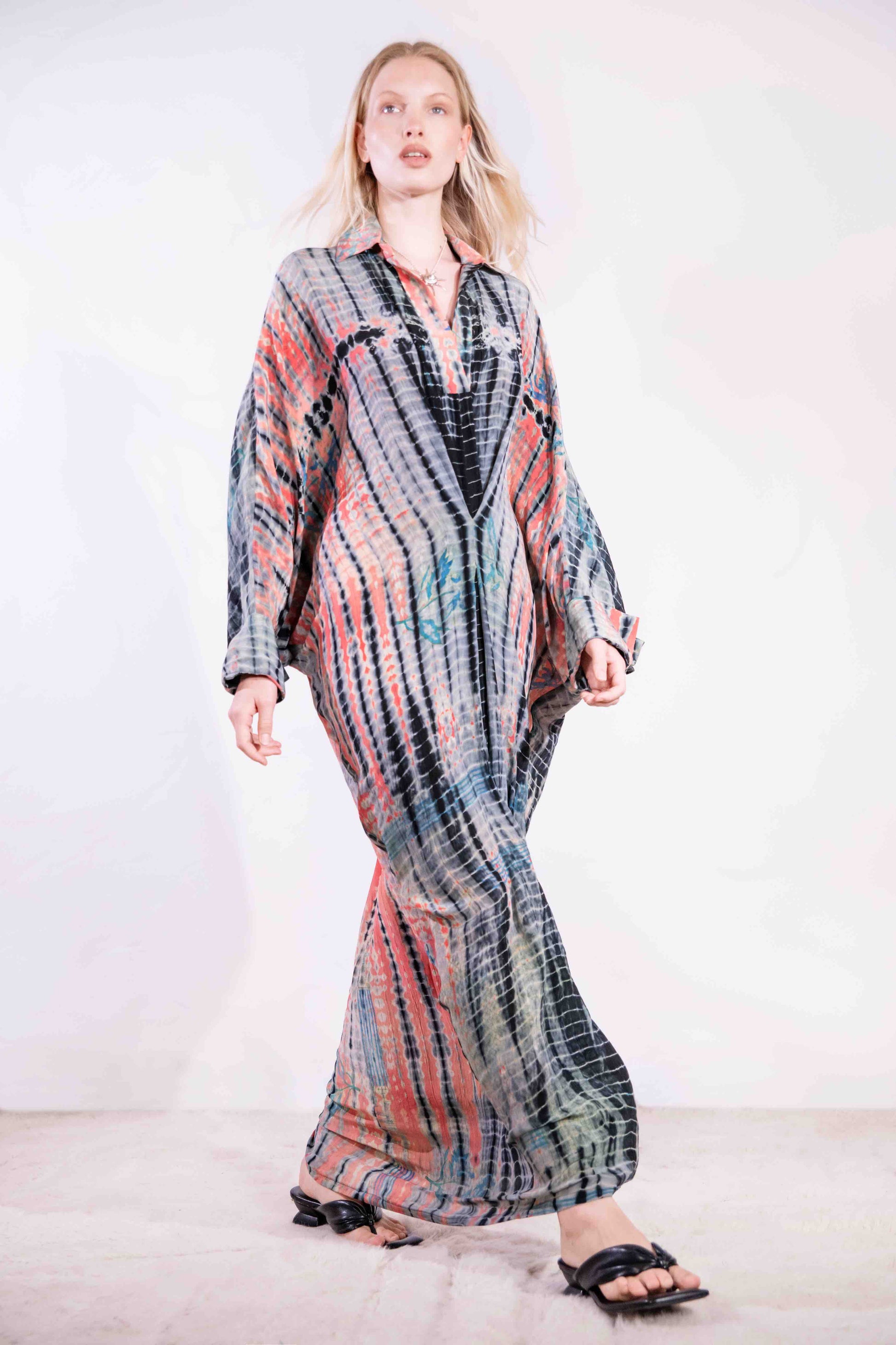 Model wearing the Barcelona Breeze Dress - a handcrafted silk dress with batwing sleeves, V-neck, and Shibori-dyed pattern, made in Italy by House of Woven Stories.