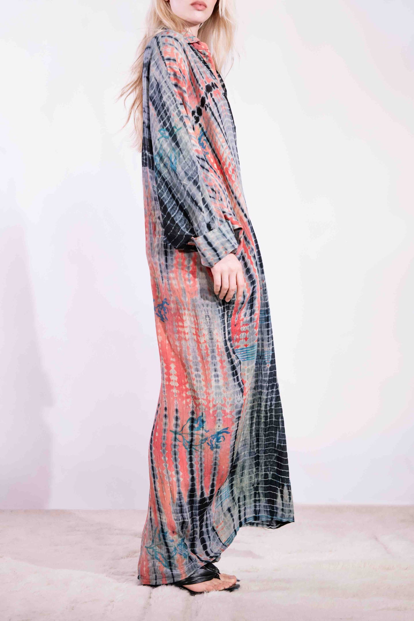 Model wearing the Barcelona Breeze Dress - a handcrafted silk dress with batwing sleeves, V-neck, and Shibori-dyed pattern, made in Italy by House of Woven Stories.