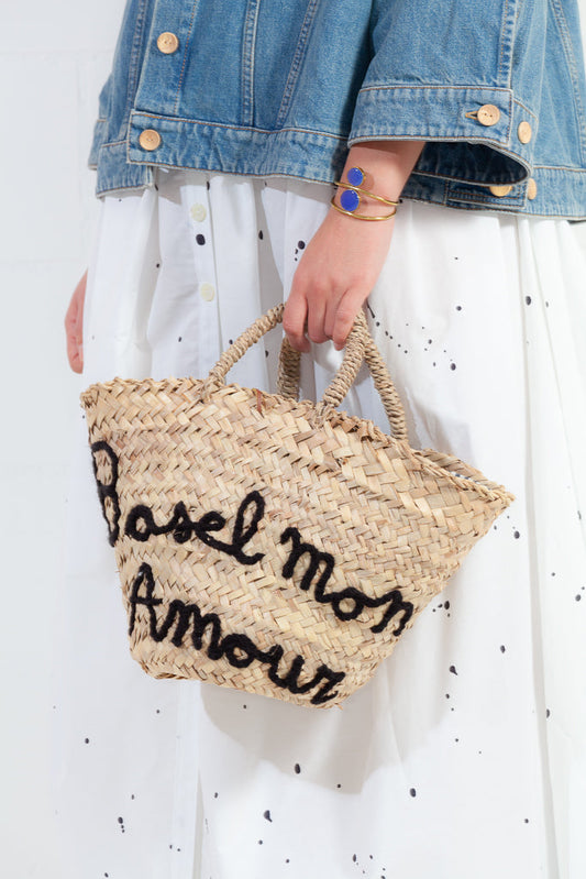 Handmade Micaela Spadoni bag with red and white striped cotton lining and Italian leather drawstring closure. Features "Basel Mon Amour" inscription in Aegean Blue. A stylish tribute to Basel. Part of Woven Stories selection.