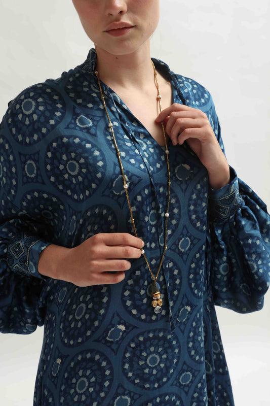 The Marion Silk Dress by Obidi is a long, elegant dress made from 100% silk repurposed from antique saris. Unique Gibori dyeing, silk lining, and side pockets combine heritage and sustainable style. Part of the House of Woven Stories selection.