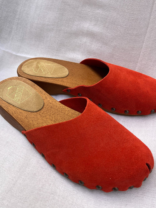 Handmade candy red clogs by Antidoti with studded sides and wooden sole, crafted in Florence, Italy. Available at House of Woven Stories.