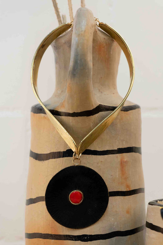 Collier Lacet necklace by Stéphane Szendy, handcrafted hammered bronze with coral-colored geometric enamel pendant, blending traditional craftsmanship with contemporary design. Part of House of Woven Stories selection.