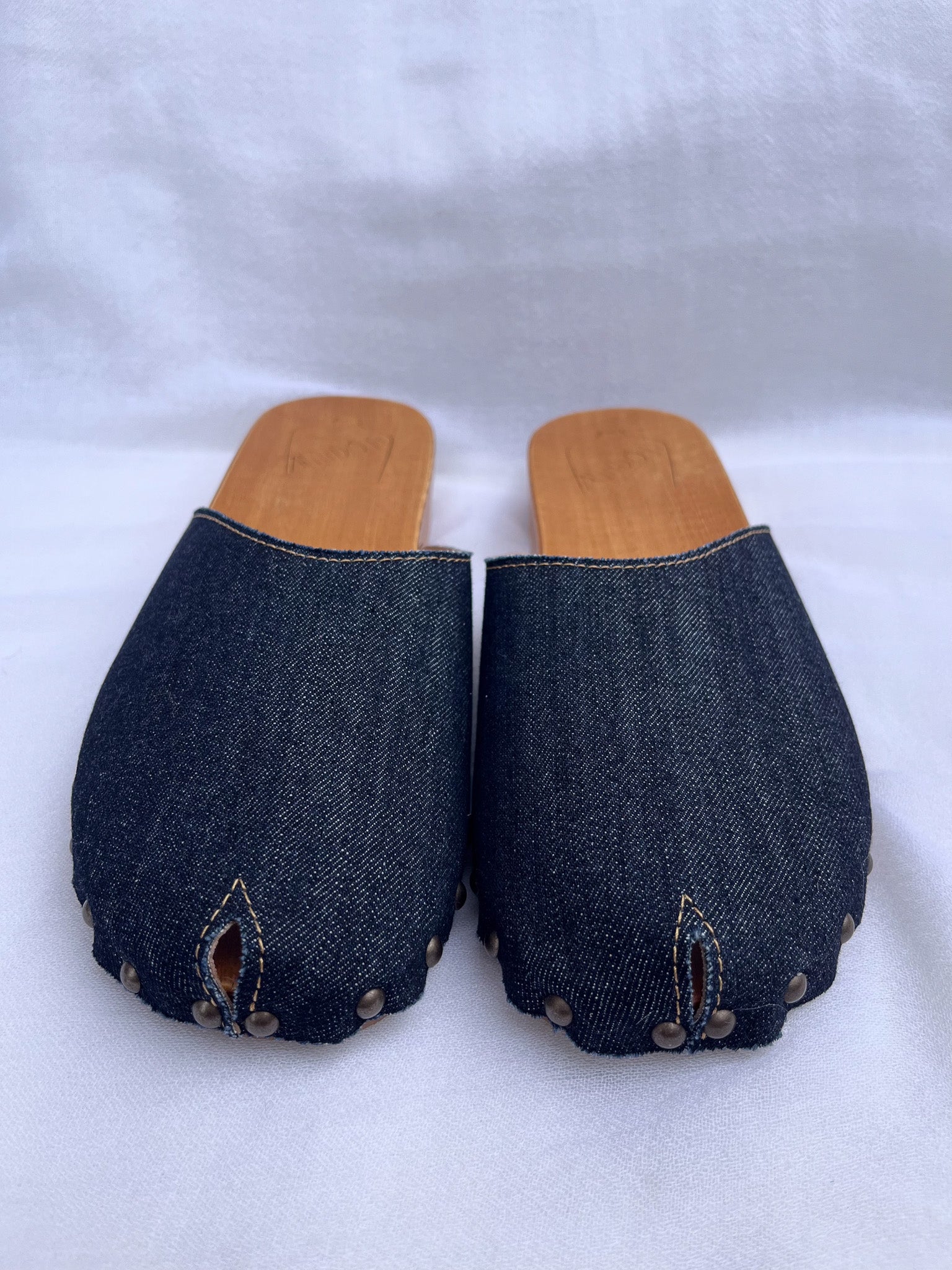 Handmade dark denim clogs by Antidoti with studded sides and wooden sole, crafted in Florence, Italy. Available at House of Woven Stories.