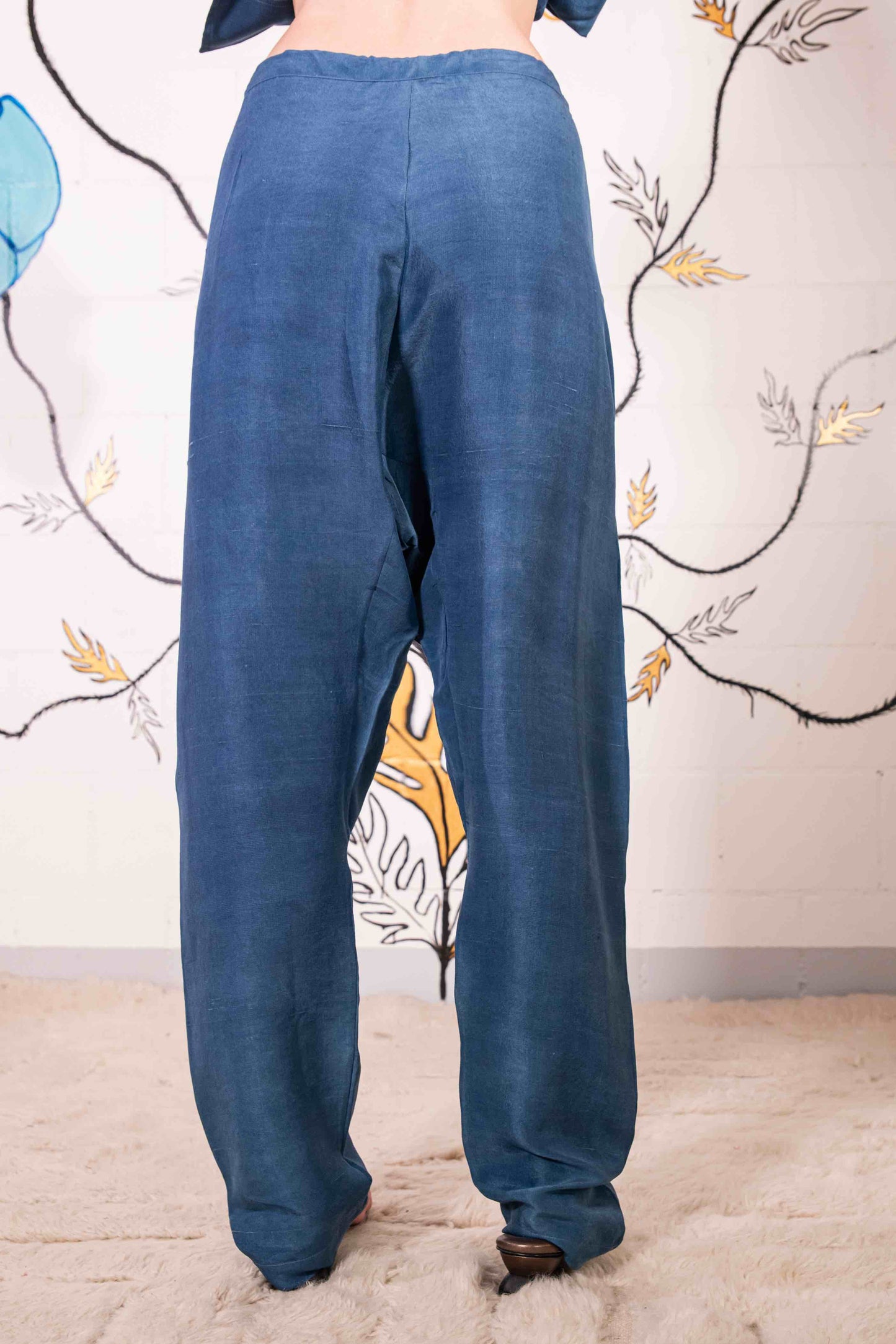 Model is wearing the Everyday Indigo Drawstring Pants with matching Cave Shirt, both in natural dyed silk by A Sacred Wrap. Handcrafted and botanically dyed, this look is available at House of Woven Stories.
