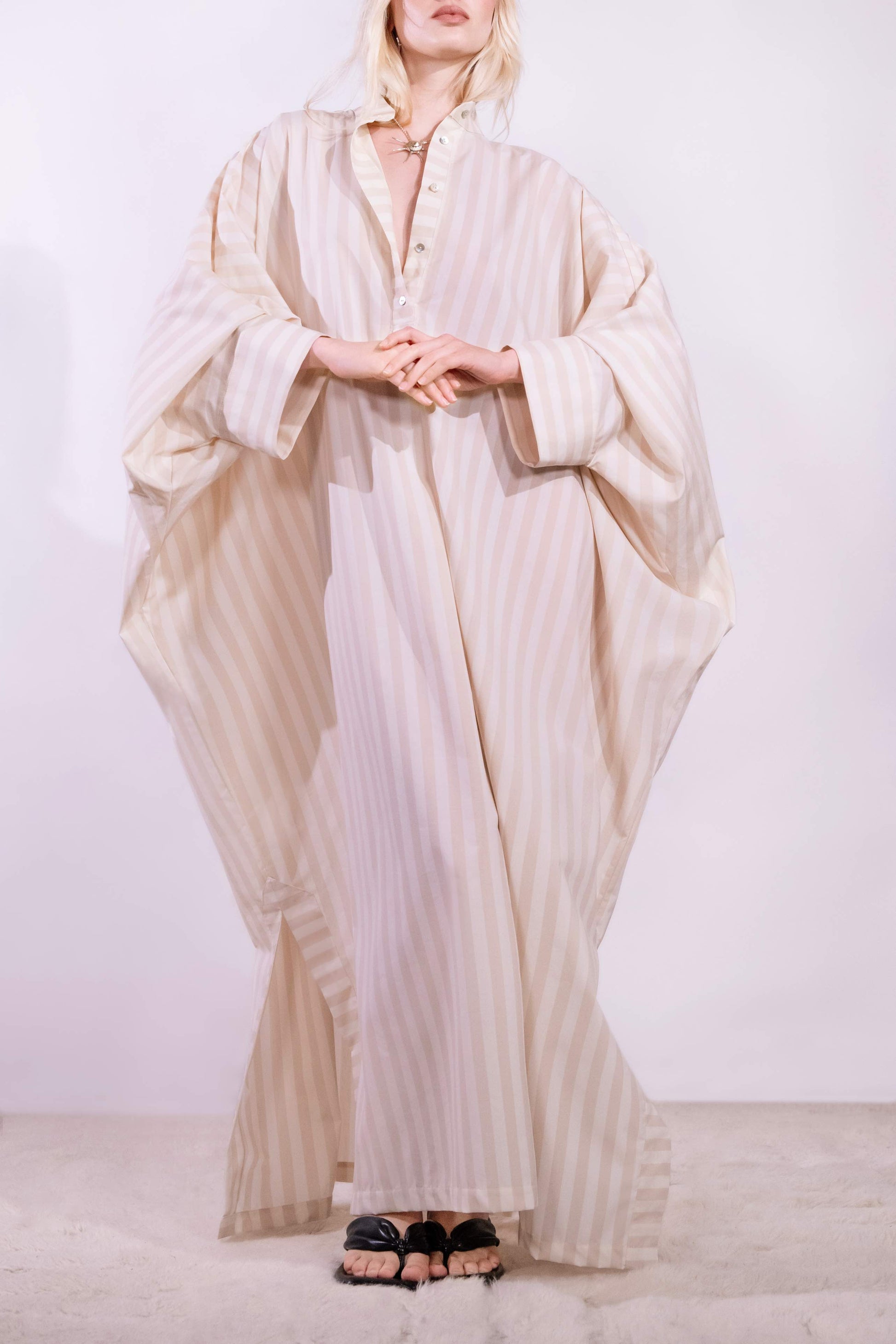 Model wearing the Fez striped shirt dress with batwing sleeves and button placket, handcrafted in Italy from 100% cotton by House of Woven Stories.