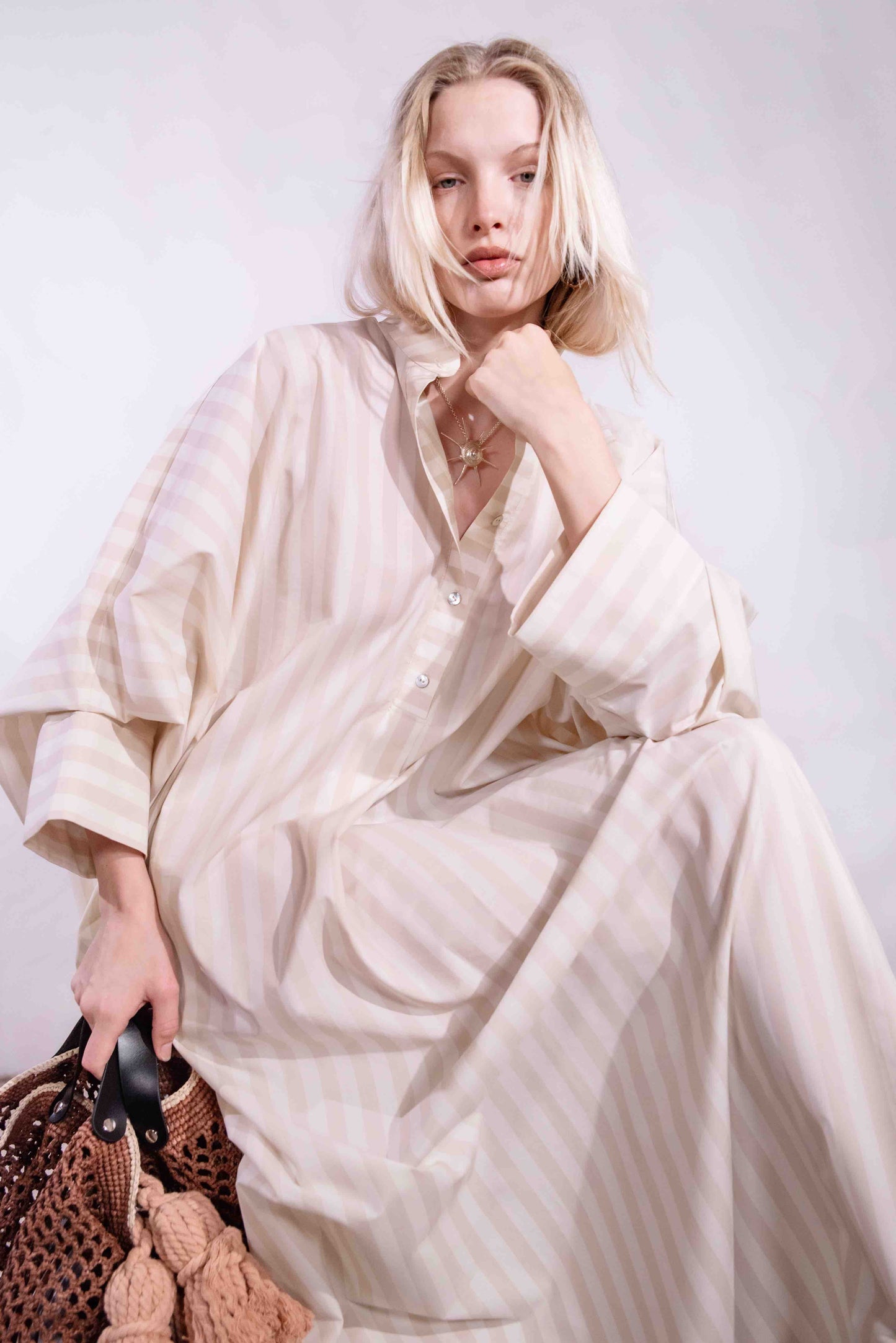 Model wearing the Fez striped shirt dress with batwing sleeves and button placket, handcrafted in Italy from 100% cotton by House of Woven Stories.