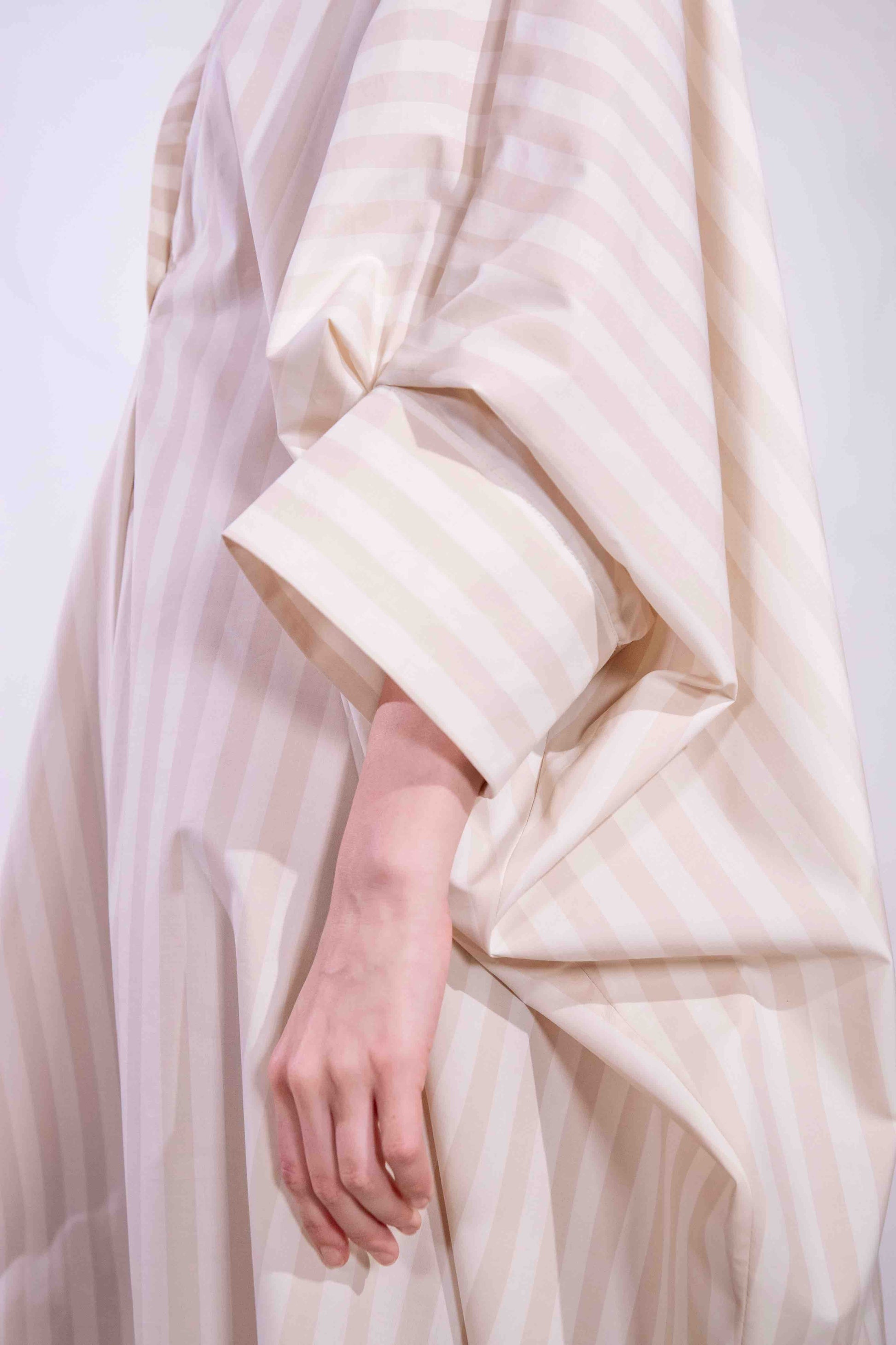 Model wearing the Fez striped shirt dress with batwing sleeves and button placket, handcrafted in Italy from 100% cotton by House of Woven Stories.