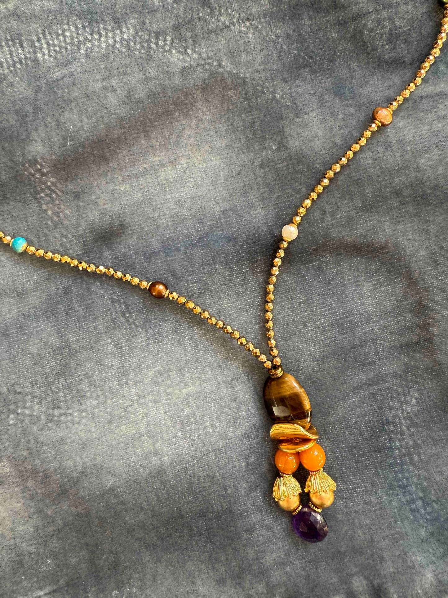 Gold and Tiger’s Eye Totem Pendant choker necklace by Ilaria Fiorentini Jewellery, featuring tiger’s eye, pyrite, turquoise, freshwater pearls, amber resin, natural amethyst, and raw brass details. Handcrafted in Italy, inspired by African and Indonesian artisan traditions. Part of House of Woven Stories selection.