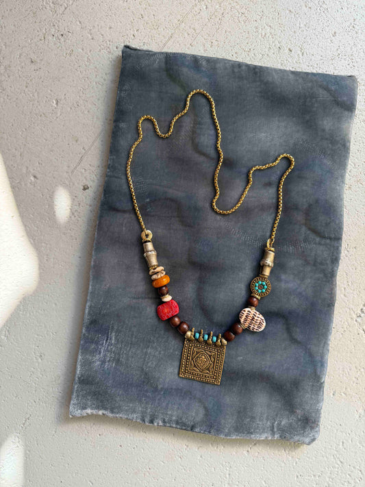 Bold handcrafted Urban Tribe Ring Square Necklace by Ilaria Fiorentini Jewellery from the House of Woven Stories selection, featuring red bamboo coral, turquoise paste, amber resin, brass and wooden details, mother-of-pearl accent, and gold-plated steel chain, inspired by African and Indonesian artisans, made in Italy.