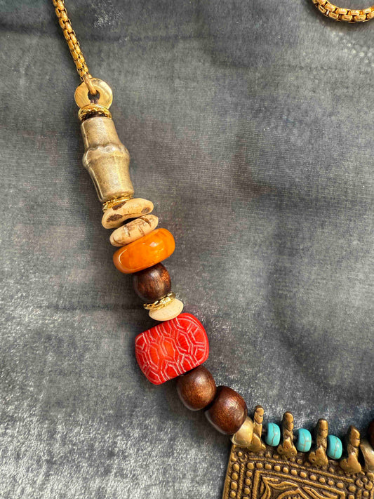Bold handcrafted Urban Tribe Ring Square Necklace by Ilaria Fiorentini Jewellery from the House of Woven Stories selection, featuring red bamboo coral, turquoise paste, amber resin, brass and wooden details, mother-of-pearl accent, and gold-plated steel chain, inspired by African and Indonesian artisans, made in Italy.