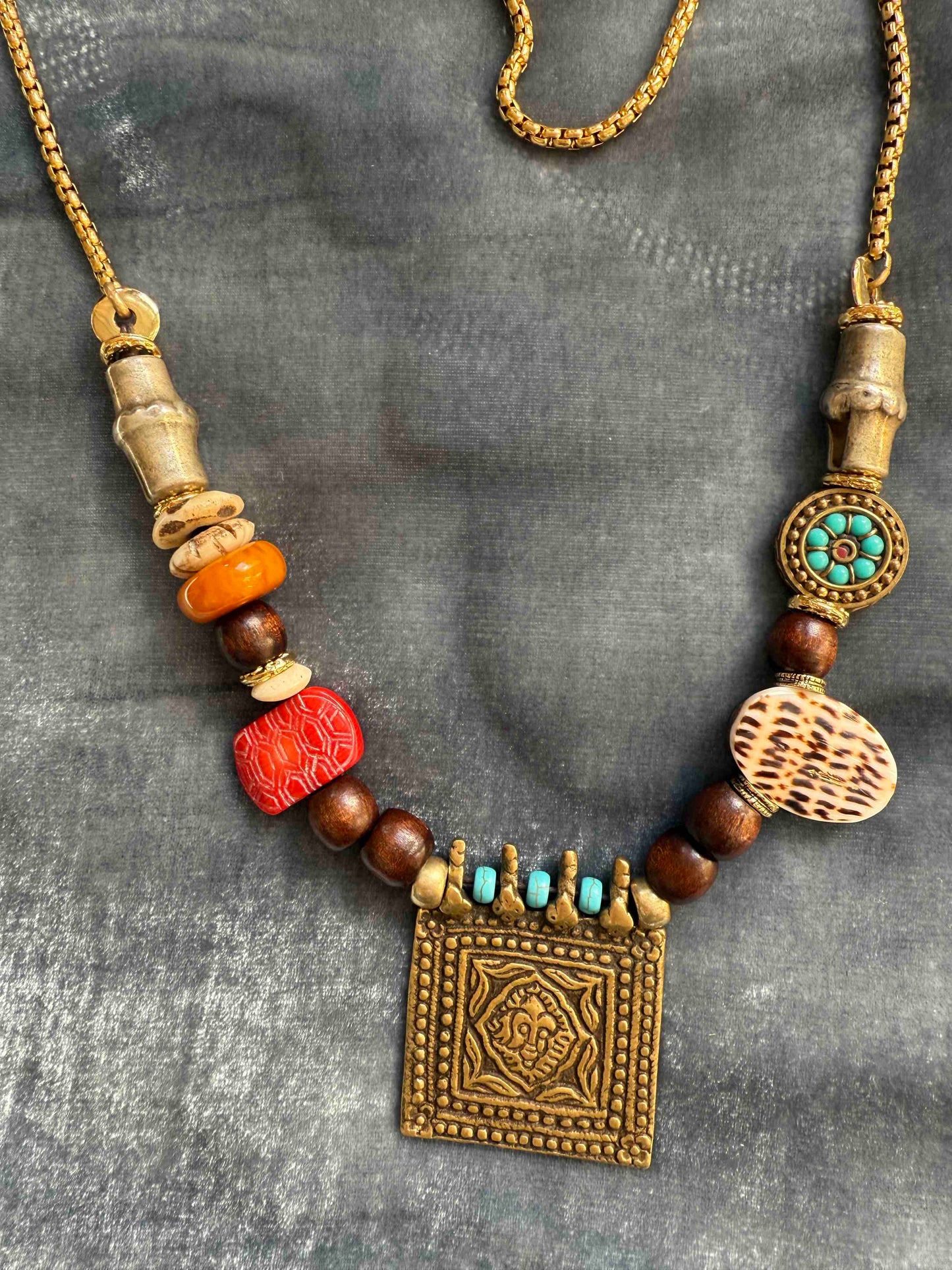 Bold handcrafted Urban Tribe Ring Square Necklace by Ilaria Fiorentini Jewellery from the House of Woven Stories selection, featuring red bamboo coral, turquoise paste, amber resin, brass and wooden details, mother-of-pearl accent, and gold-plated steel chain, inspired by African and Indonesian artisans, made in Italy.