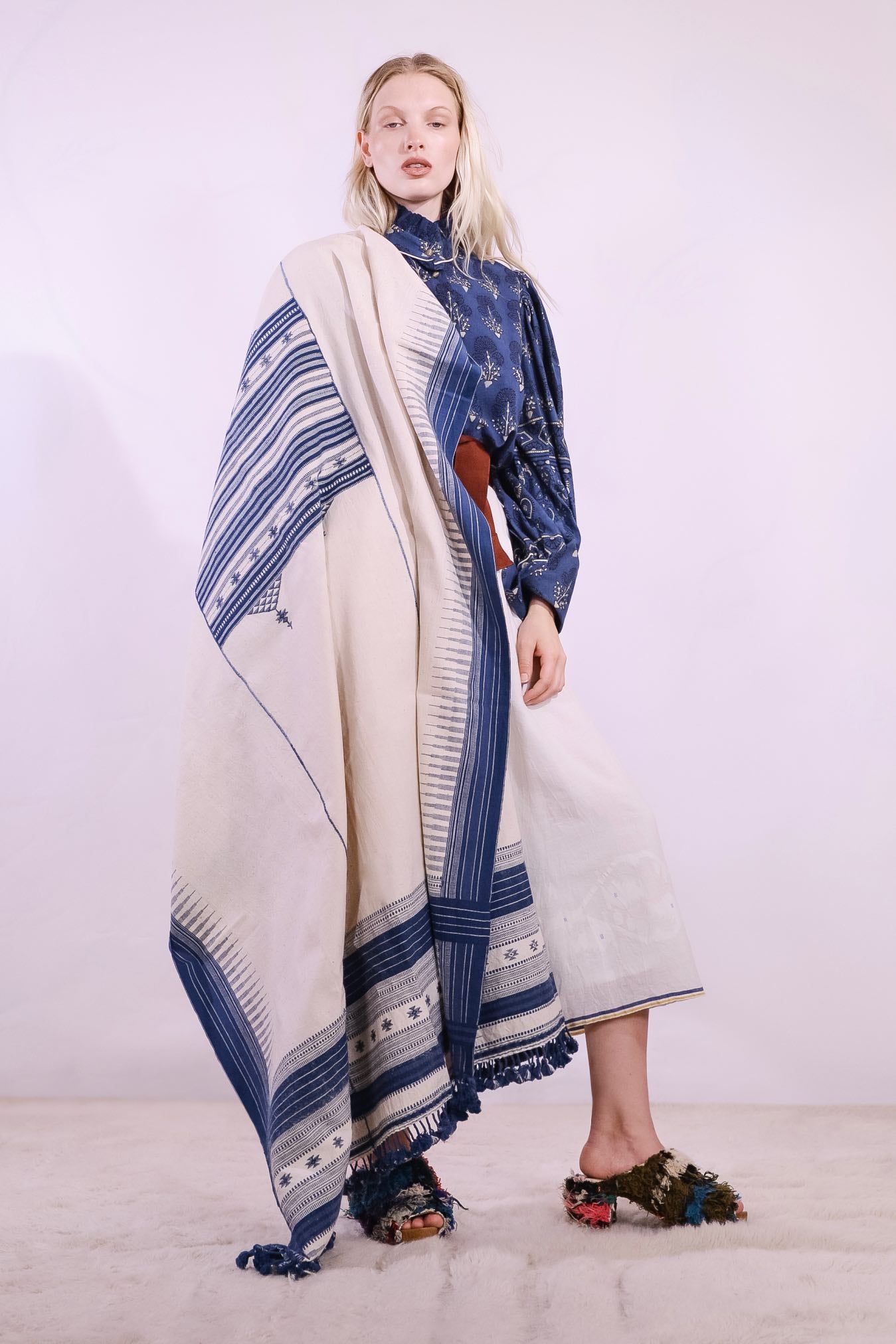 Handwoven kala cotton throw with embroidered panels by Shamji Vankar Vishram Valji, crafted in Bhujodi, India. Made from handspun yarn for a rich, textured feel. A heritage piece curated by House of Woven Stories, blending tradition, sustainability, and artisan craftsmanship. Available at House of Woven Stories.